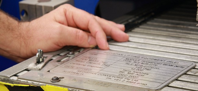 A hand removing a completed laser job from one of our laser machines